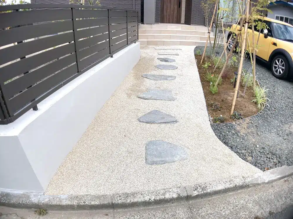 秋田市K様邸の和モダン外構。化粧砂利の庭に、お客様が再利用した自然石の飛び石が続く玄関アプローチ。