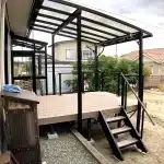 秋田市T様邸の、黒いフレームと透明屋根のテラス屋根付き樹脂デッキを室内側から見た様子。