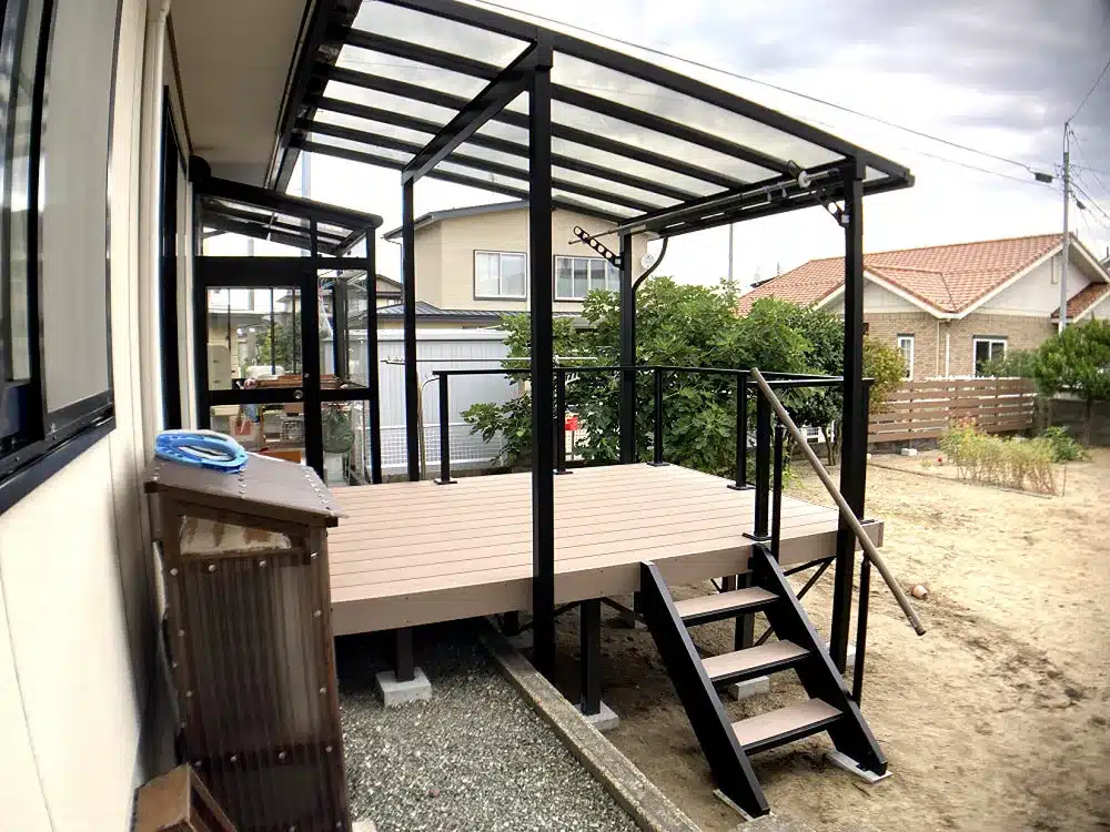 秋田市T様邸の、黒いフレームと透明屋根のテラス屋根付き樹脂デッキを室内側から見た様子。