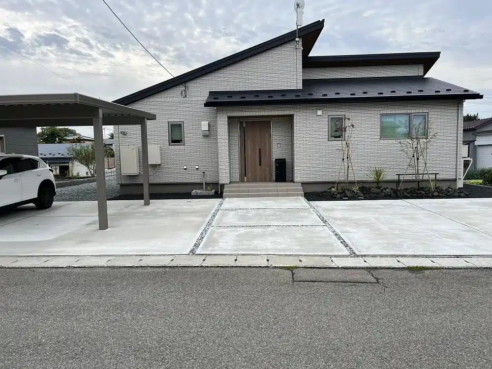 大館市S様邸のモダンな外観と駐車スペース、門柱周辺の様子。